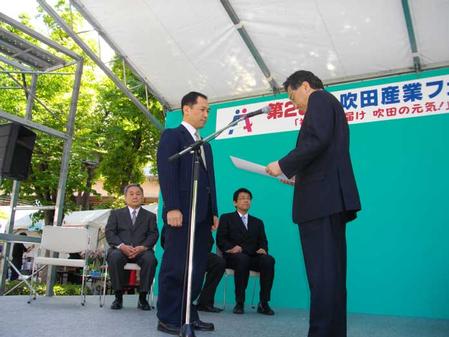 Shigehiro Teranishi, President of the fair, presents a Suita Industry Award to Tetsuro Nishimura, President of Nihon Superior Co. Ltd.
